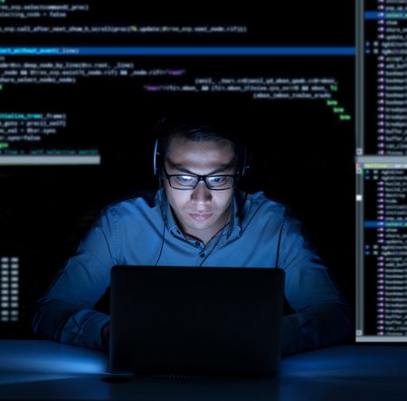 Young programmer in headphones working on new project